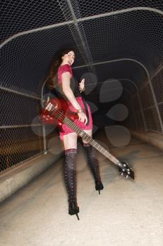 Royalty Free Photo of a Woman Walking With an Electric Guitar