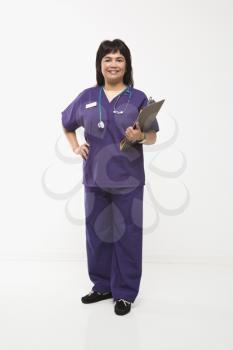 Royalty Free Photo of a Woman Dressed in Scrubs Holding a Clipboard