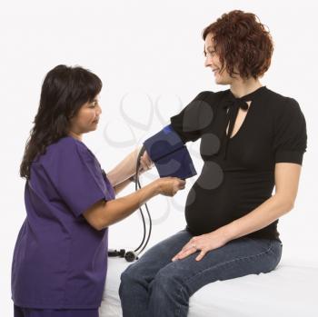 Royalty Free Photo of a Pregnant Woman Having Her Blood Pressure Checked by a Nurse
