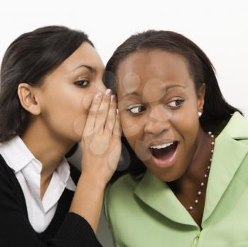 Royalty Free Photo of a Woman Whispering in Her Friend's Ear