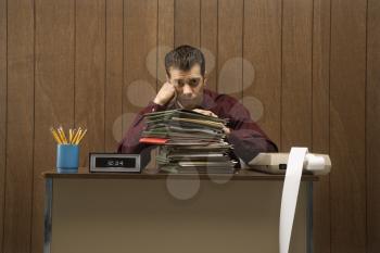 Royalty Free Photo of a Businessman Looking Over a Tall Stack of Folders