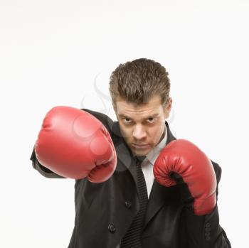 Royalty Free Photo of a Man Wearing a Suit and Punching with Boxing Gloves