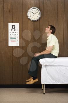 Royalty Free Photo of a Man Waiting on a Table in a Retro Doctor's Office