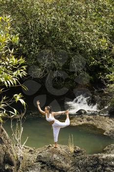 Royalty Free Photo of a Woman Doing Yoga Balancing on a Boulder by Creek in Maui, Hawaii