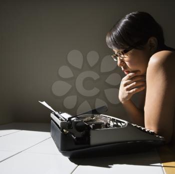Royalty Free Photo of a Woman Sitting at a Kitchen Table Reading Paper in a Typewriter