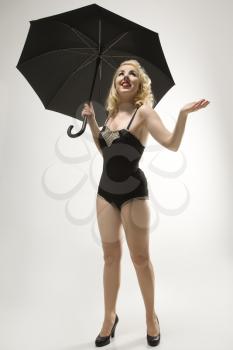 Royalty Free Photo of a Woman Wearing a Retro Swimsuit in a Pinup Pose With an Umbrella