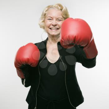 Royalty Free Photo of an Older Woman Wearing Boxing Gloves and Throwing Punches