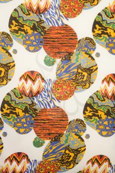 Close-up of colorful vintage fabric with orbs of abstract designs printed on polyester.
