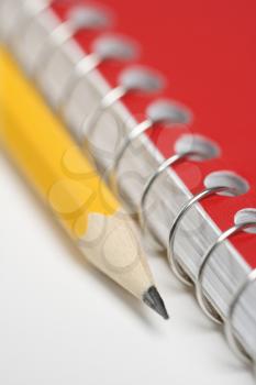 Royalty Free Photo of a Sharp Pencil Placed on a Red Spiral Bound Notebook