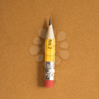 Royalty Free Photo of a Short Number Two Pencil on a Tan Background