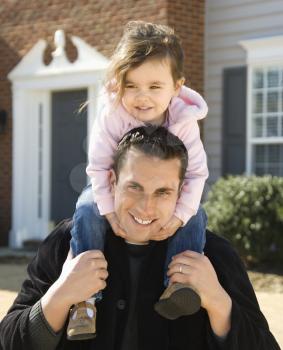 Royalty Free Photo of a Father Carrying His Daughter on His Shoulders