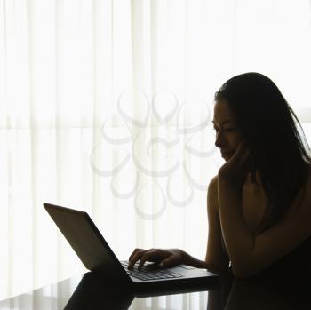 Royalty Free Photo of Silhouette of a Woman on a Laptop