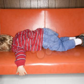 Royalty Free Photo of a Boy Sleeping on a Vinyl Sofa