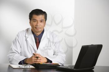 Royalty Free Photo of a Doctor Sitting at a Desk With a Laptop