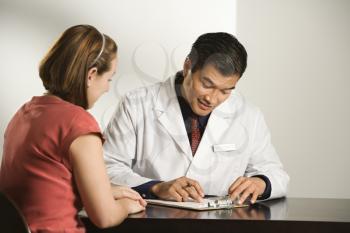 Royalty Free Photo of a Male Doctor Consulting With a Female Patient