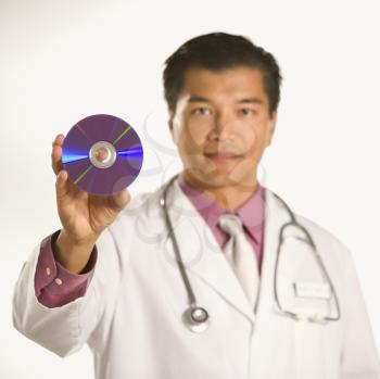 Royalty Free Photo of a Male Doctor Holding Out a Compact Disc