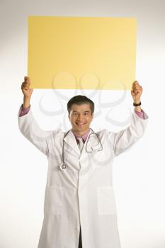 Royalty Free Photo of a Male Doctor Holding Up a Sign
