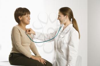 Royalty Free Photo of a Female Doctor Examining a Middle-Aged Female Patient With a Stethoscope