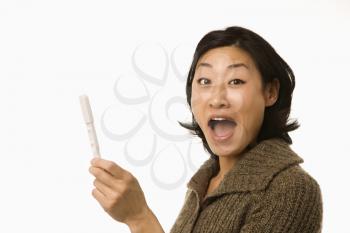 Royalty Free Photo of a Woman Holding Up a Pregnancy Test Looking Excited