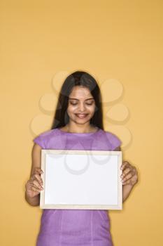 Pretty mid adult Indian woman holding blank sign.