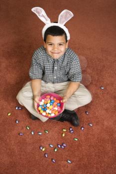 Royalty Free Photo of a Boy Wearing Bunny Ears Sitting With a Bowl of Chocolate Eggs