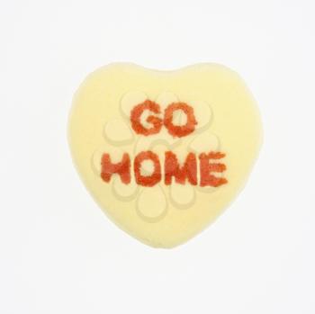 Royalty Free Photo of a Yellow Candy Heart That Reads Go Home