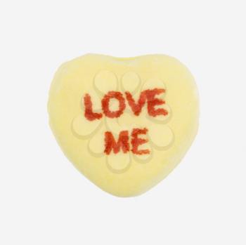 Royalty Free Photo of a Yellow Candy Heart That Reads Love Me