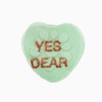 Green candy heart that reads yes dear against white background.