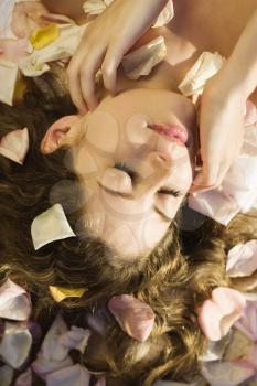 Royalty Free Photo of a Woman Lying Down With Rose Petals in Her Hair 