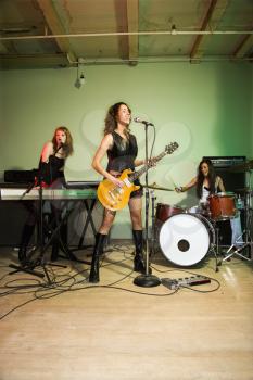 Royalty Free Photo of a Girl Band Playing Their Instruments