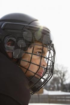 Royalty Free Photo of a Hockey Player Boy in a Cage Helmet With a Look of Concentration