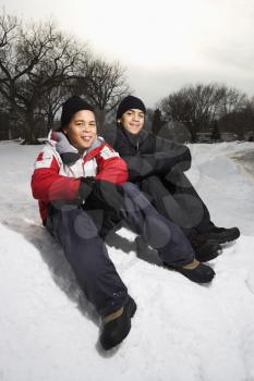 Royalty Free Photo of Two Boys Sitting in the Snow Smiling