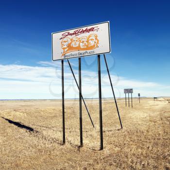 Royalty Free Photo of a South Dakota Road Sign With Mount Rushmore in a Rural Field