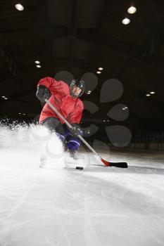 Royalty Free Photo of a Female Hockey Player Skating on Ice 