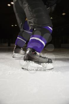 Royalty Free Photo of a Hockey Player's Legs and Skates on a Ice Rink