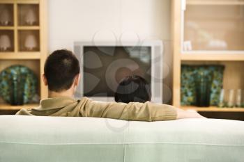 Royalty Free Photo of a Couple Sitting on a Couch Watching TV