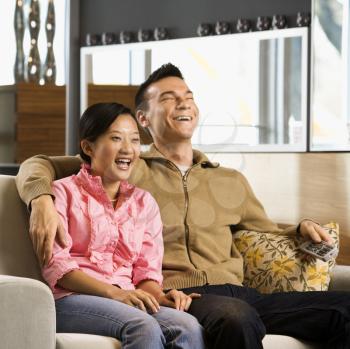 Royalty Free Photo of a Couple Laughing While Watching Television