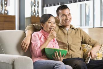 Royalty Free Photo of a Couple Watching Television Together