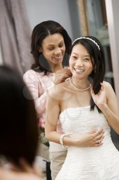 Royalty Free Photo of a Woman Putting a Necklace on a Bride