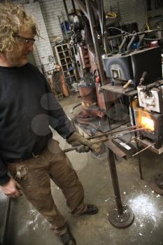Royalty Free Photo of a Male Metal Smith Heating Metal in a Forge