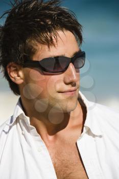 Royalty Free Photo of a Head and Shoulder Portrait of an Attractive Man Wearing Sunglasses on Maui, Hawaii Beach