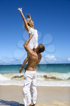 Royalty Free Photo of a Man Holding a Woman Up Out of Water on Maui, Hawaii Beach