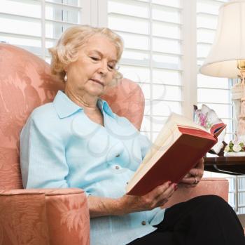 Royalty Free Photo of an Older Woman Sitting Reading a Book