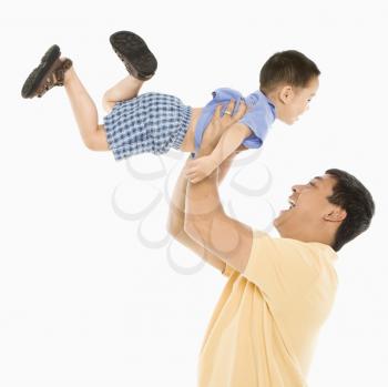 Royalty Free Photo of a Father Lifting His Son Up