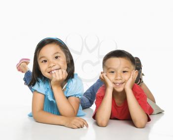 Royalty Free Photo of a Brother and Sister Lying on the Floor With Head on Hands
