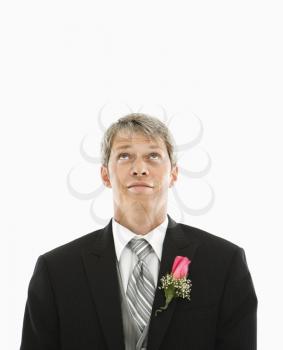 Royalty Free Photo of a Man in a Tuxedo with Boutonniere Looking Up