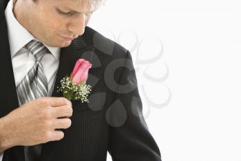 Royalty Free Photo of a Groom Adjusting His Boutonniere