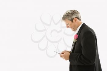 Royalty Free Photo of a Groom Using His Cellphone