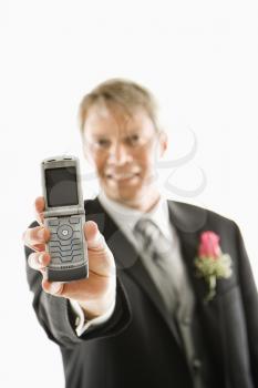 Royalty Free Photo of a Groom Holding Out His Cellphone