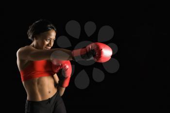 Royalty Free Photo of a Woman Wearing Boxing Gloves Throwing a Punche
